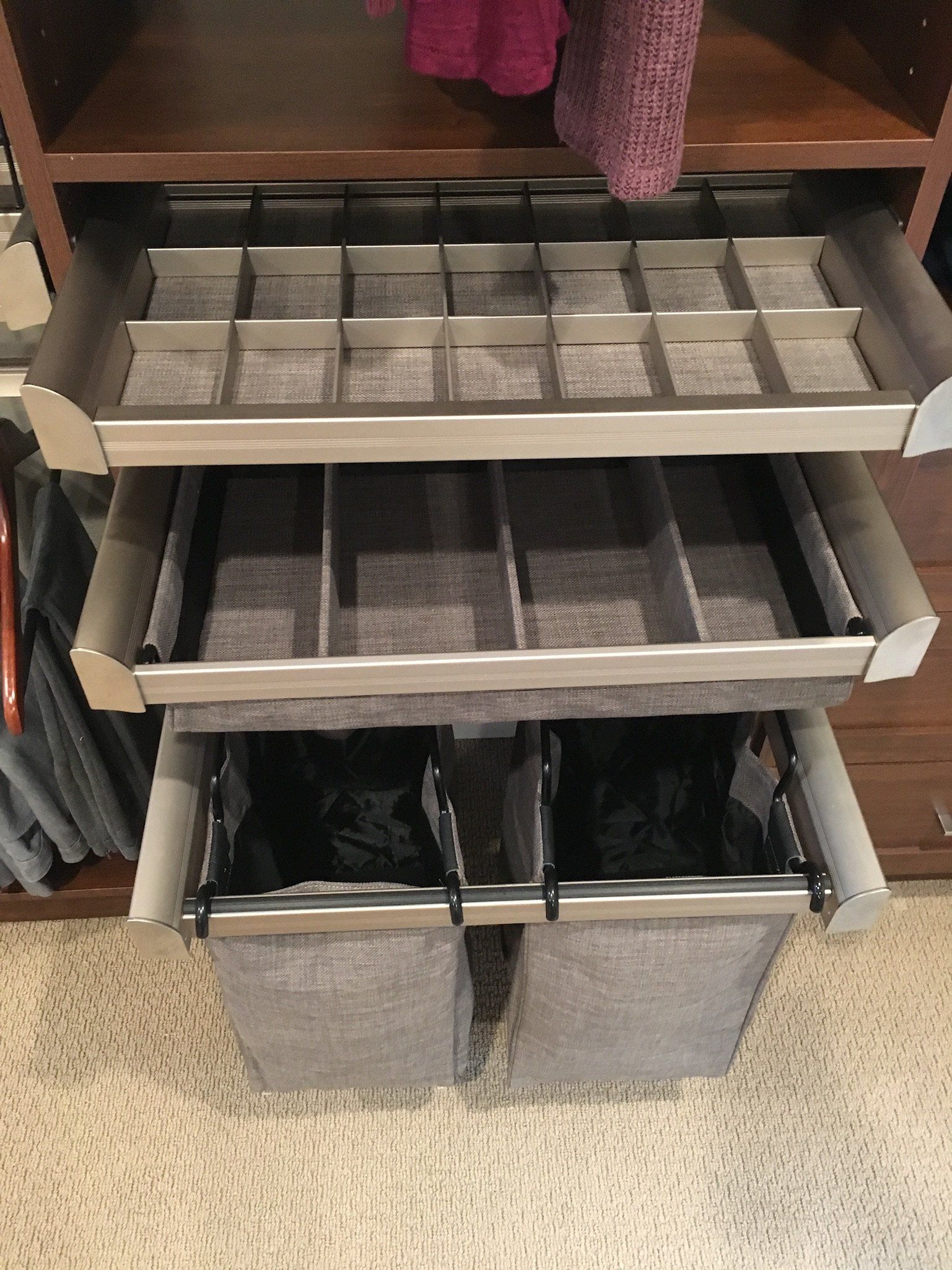 A closet with three drawers filled with clothes.