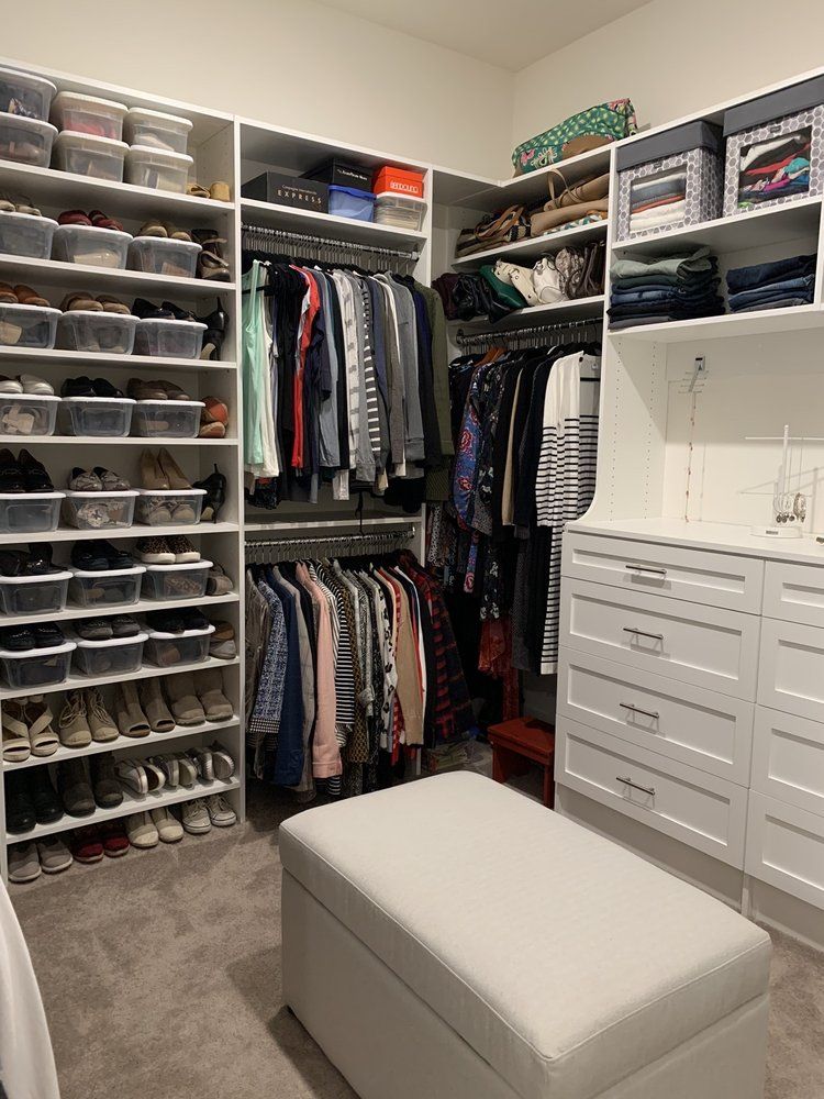 A walk in closet filled with lots of clothes and shoes.