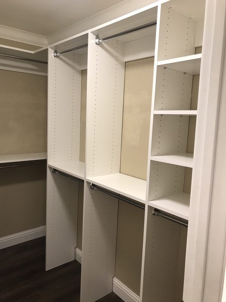 A walk in closet with lots of shelves and hanging clothes.