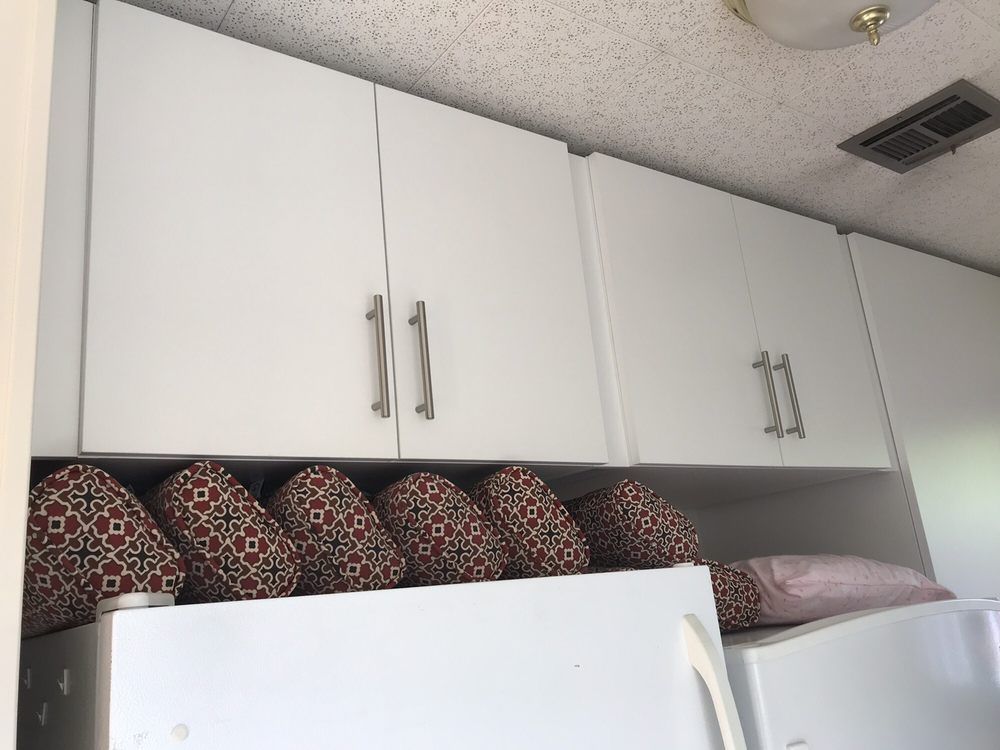 A kitchen with white cabinets and a white refrigerator