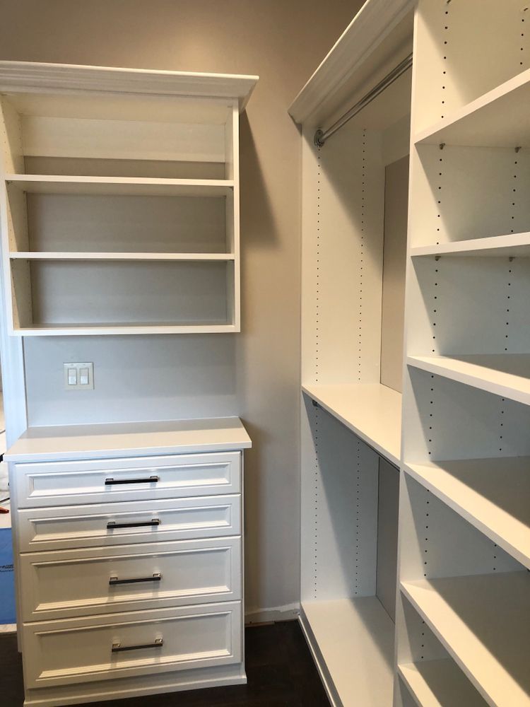 A walk in closet with lots of shelves and drawers