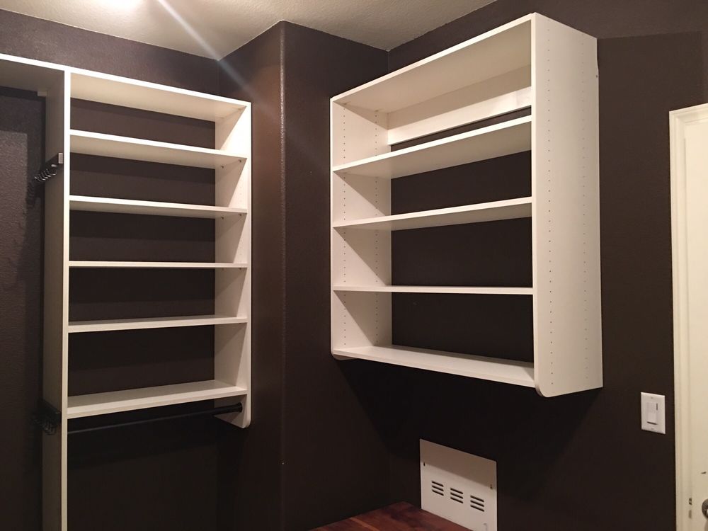 A walk in closet with brown walls and white shelves