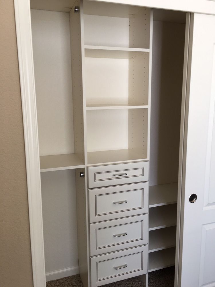 A closet with shelves and drawers and a sliding door.