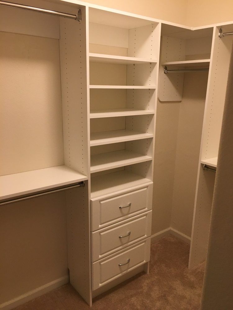 A walk in closet with lots of shelves and drawers.