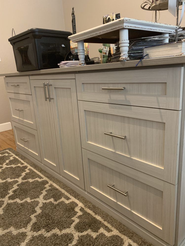 A dresser with drawers and cabinets in a room with a rug.
