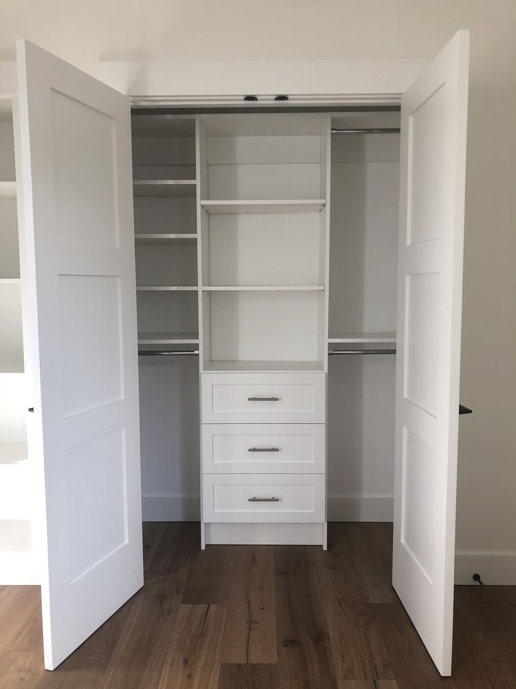 A closet with shelves and drawers and the doors open