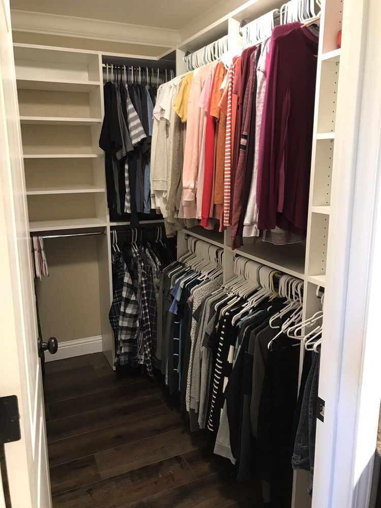 A walk in closet filled with lots of clothes and shelves.
