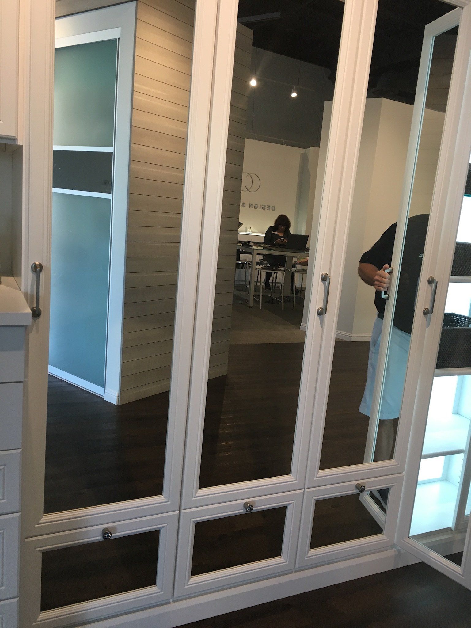 A person is standing in front of a mirror in a room.