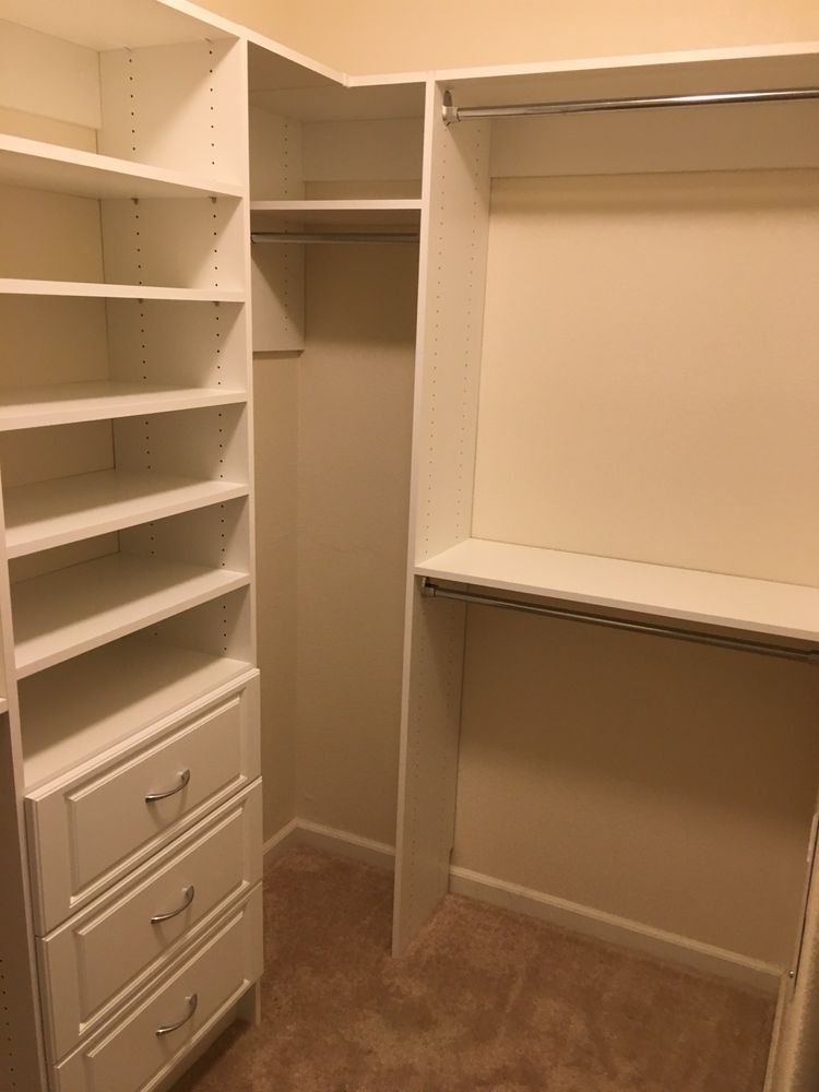 A walk in closet with lots of shelves and drawers.