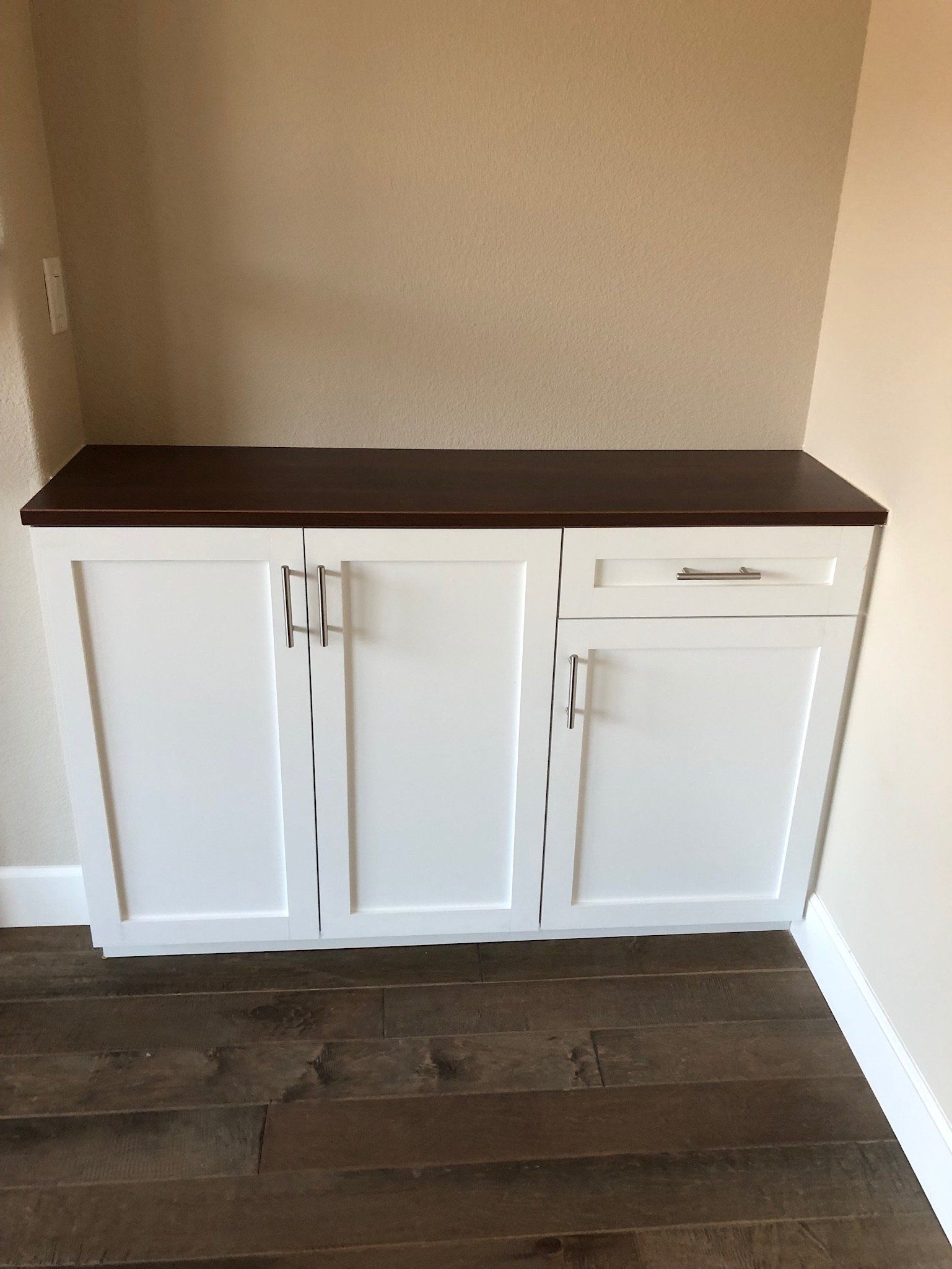 A white cabinet with a wooden top in a room