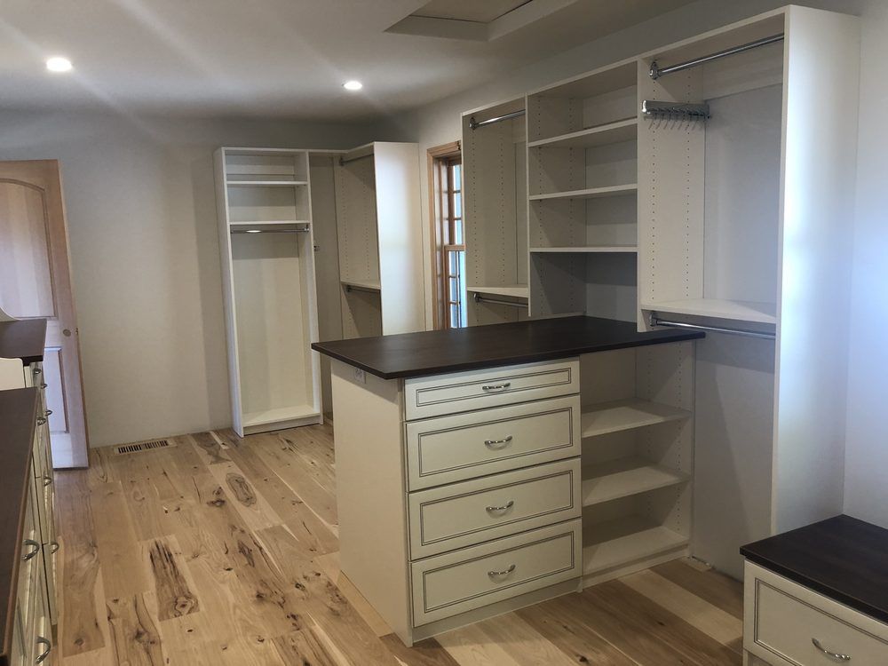 A walk in closet with lots of shelves and drawers.