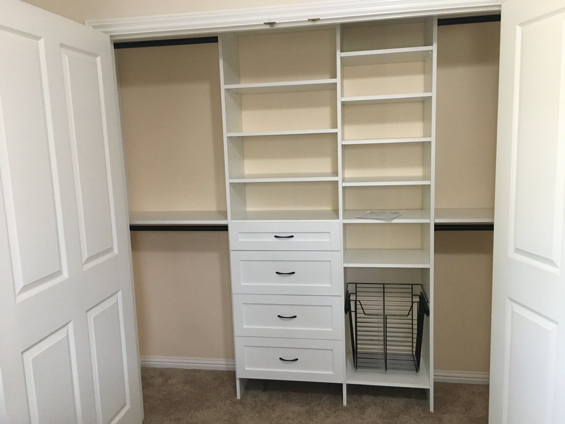 A closet with white shelves , drawers , and a basket.