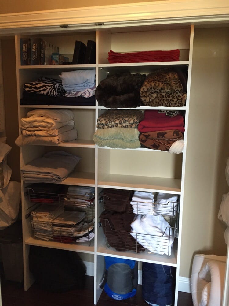 A closet filled with lots of clothes and blankets.