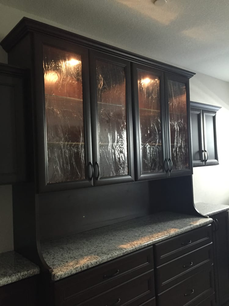 A kitchen with black cabinets and granite counter tops