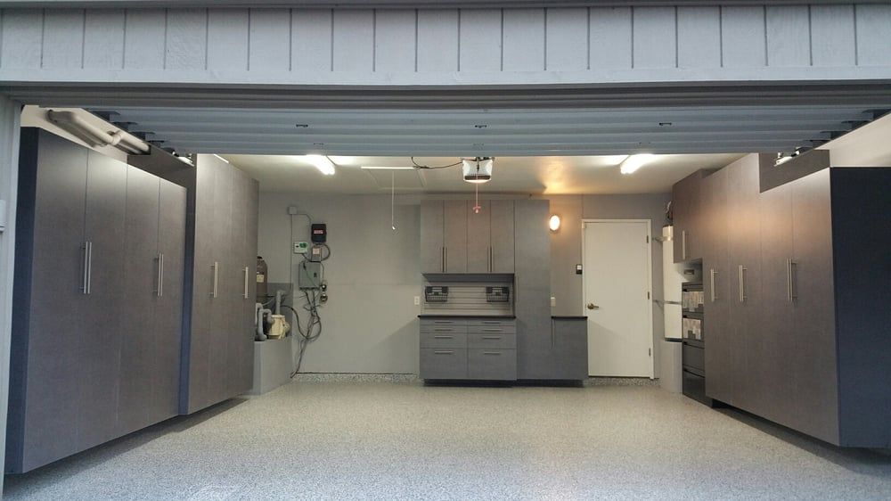A garage with gray cabinets and a white door