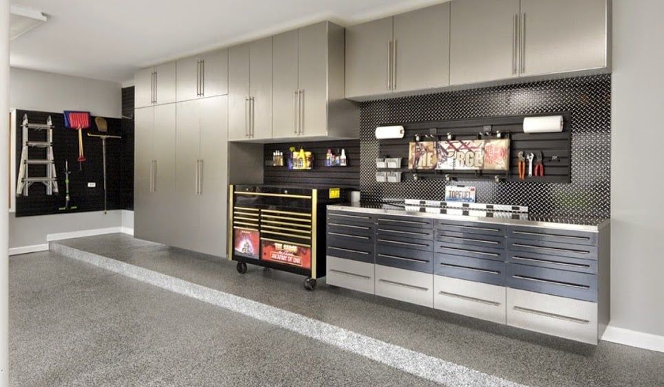 A garage with lots of cabinets and a stainless steel sink.
