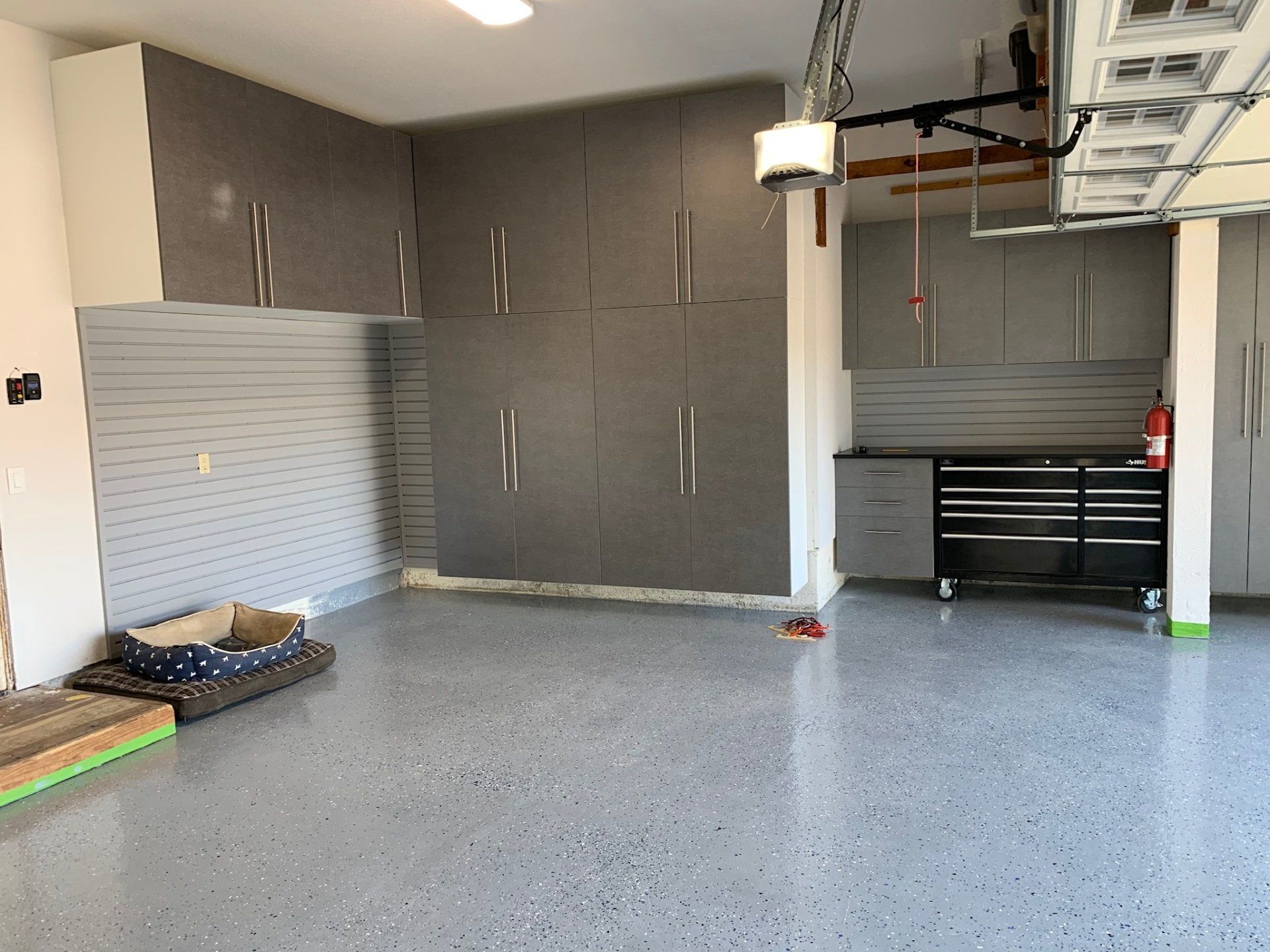 A garage with lots of cabinets and a dog bed