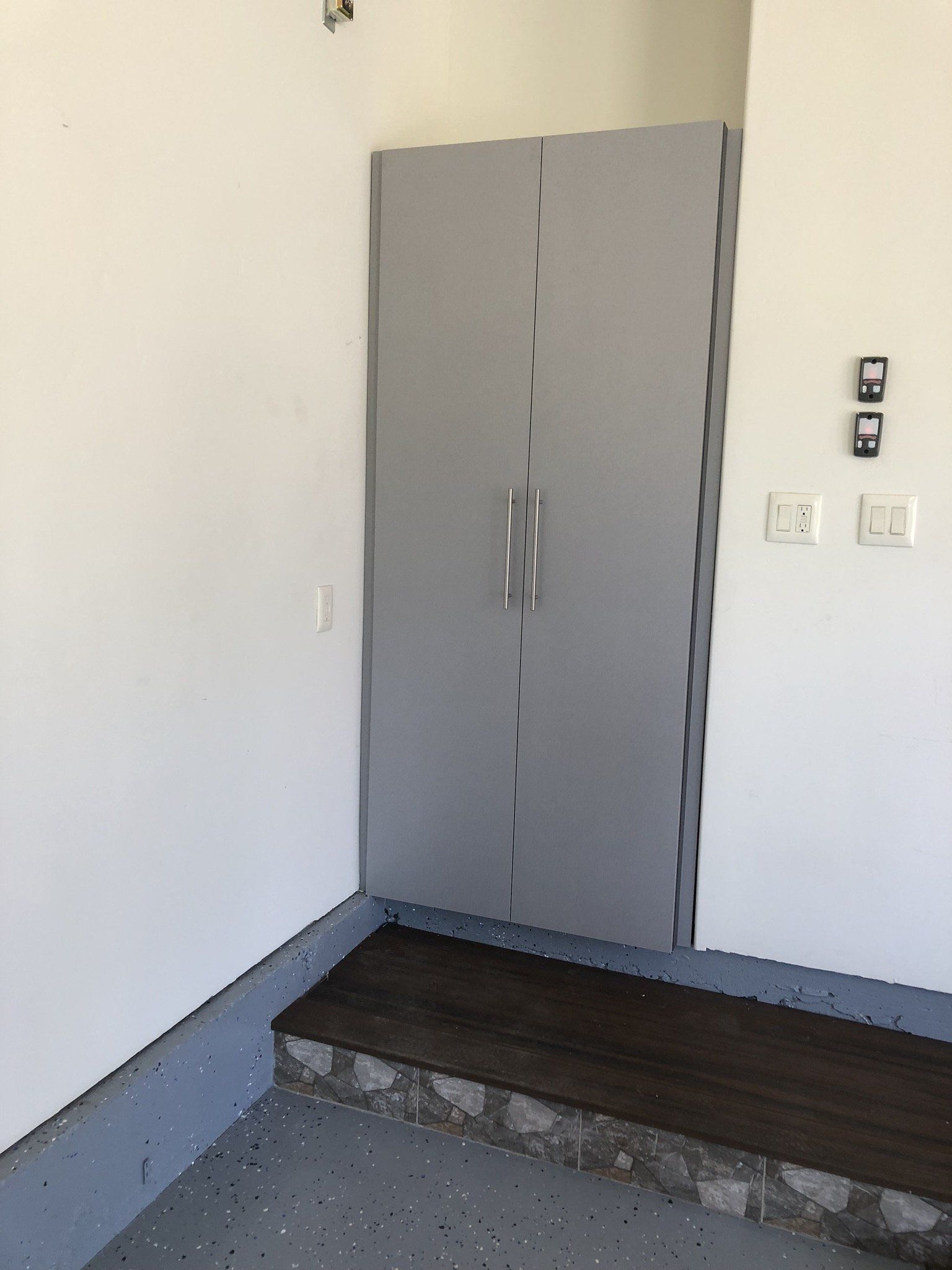 A garage with a gray door and a wooden floor