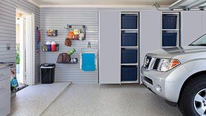 A car is parked in a garage with lots of storage space.
