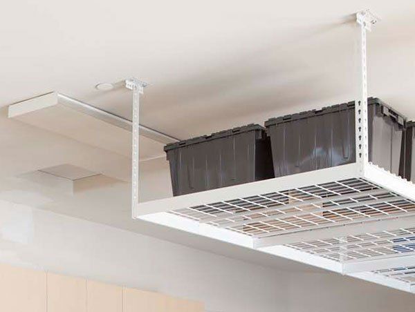 A white ceiling rack with black bins hanging from it.