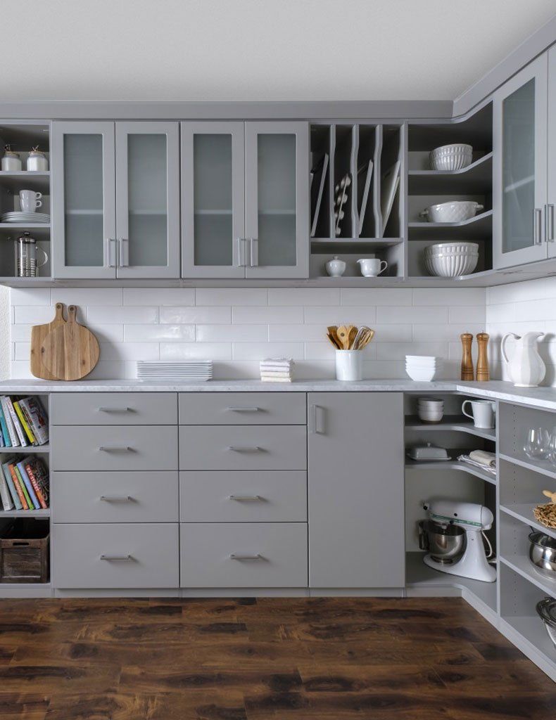 A kitchen with gray cabinets and a wooden floor.
