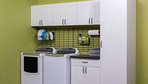 A laundry room with a washer and dryer and cabinets.