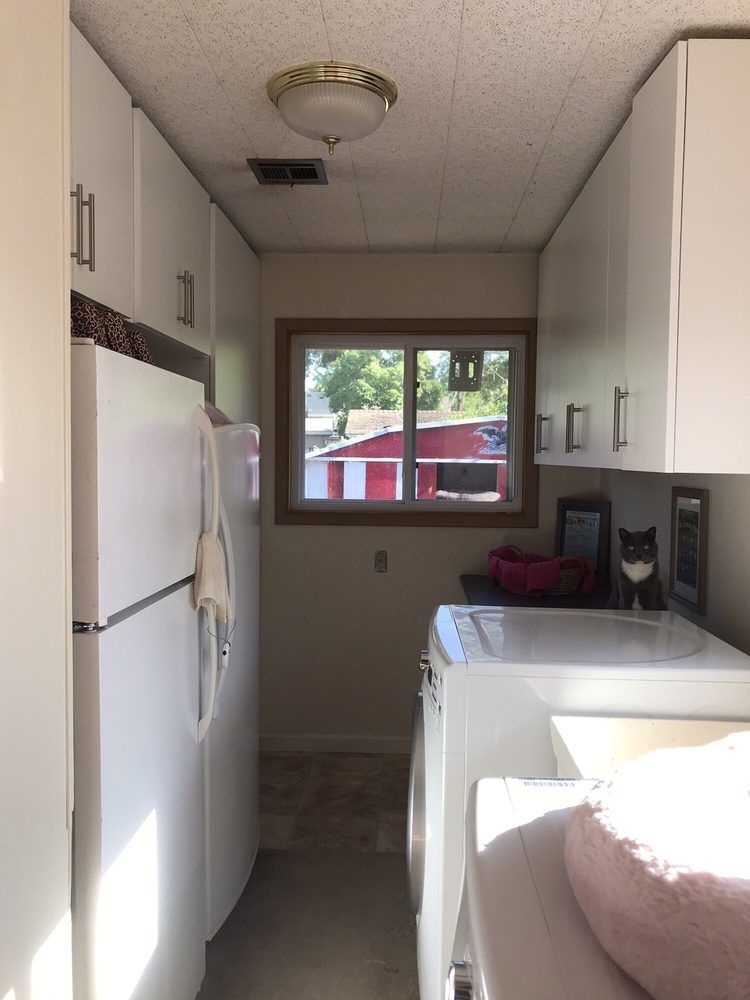 A laundry room with a washer and dryer and a refrigerator