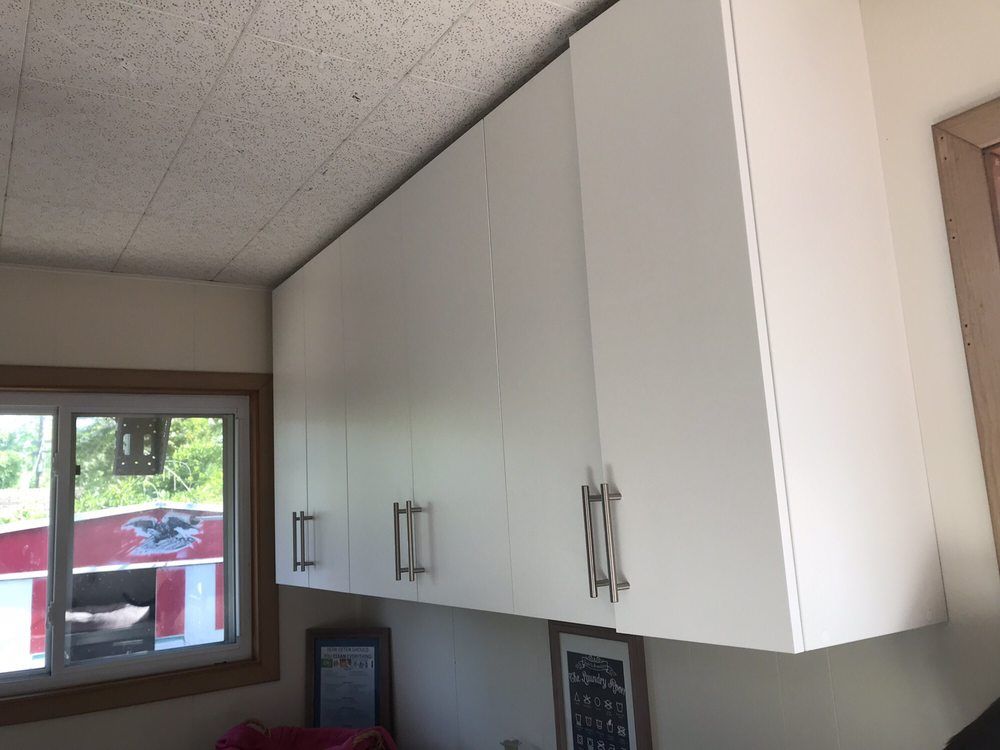 A kitchen with white cabinets and a window