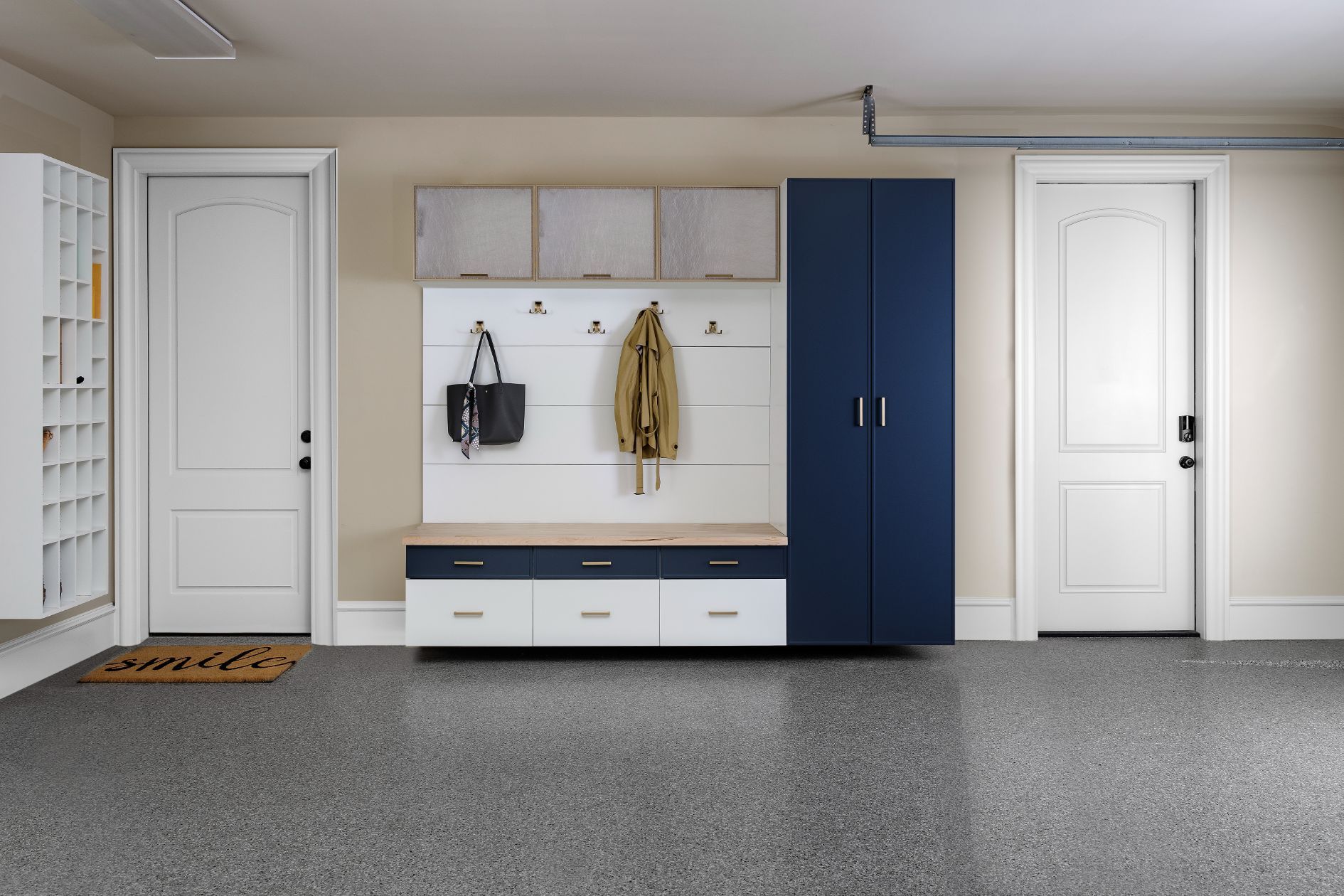 A garage with blue and white cabinets and a bench.