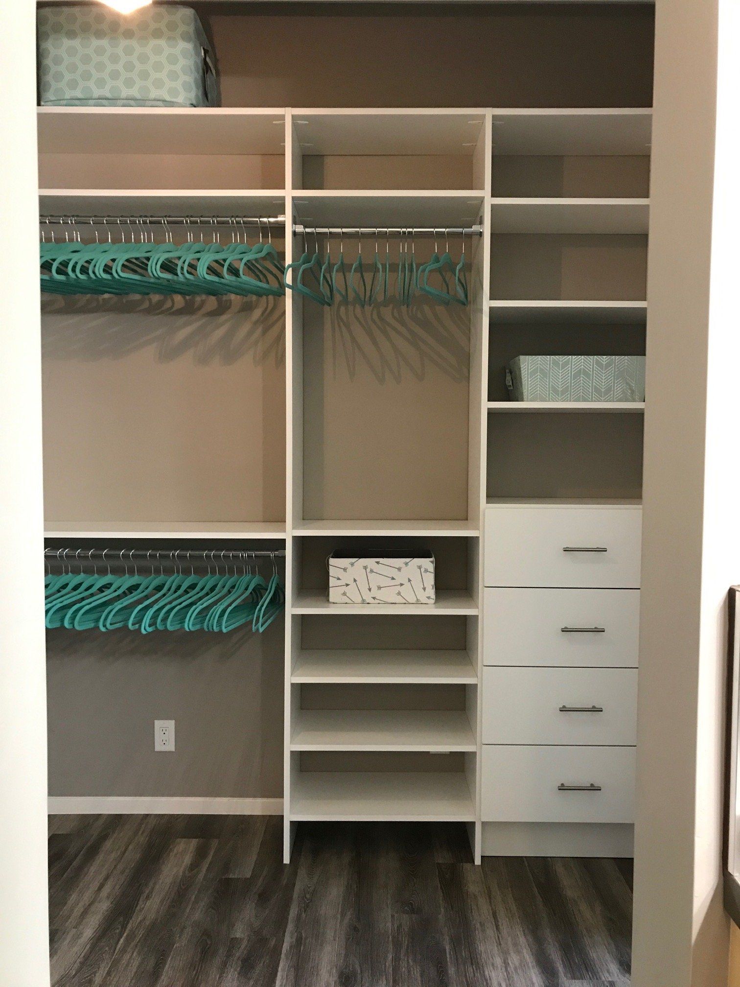 A walk in closet with lots of shelves and drawers.