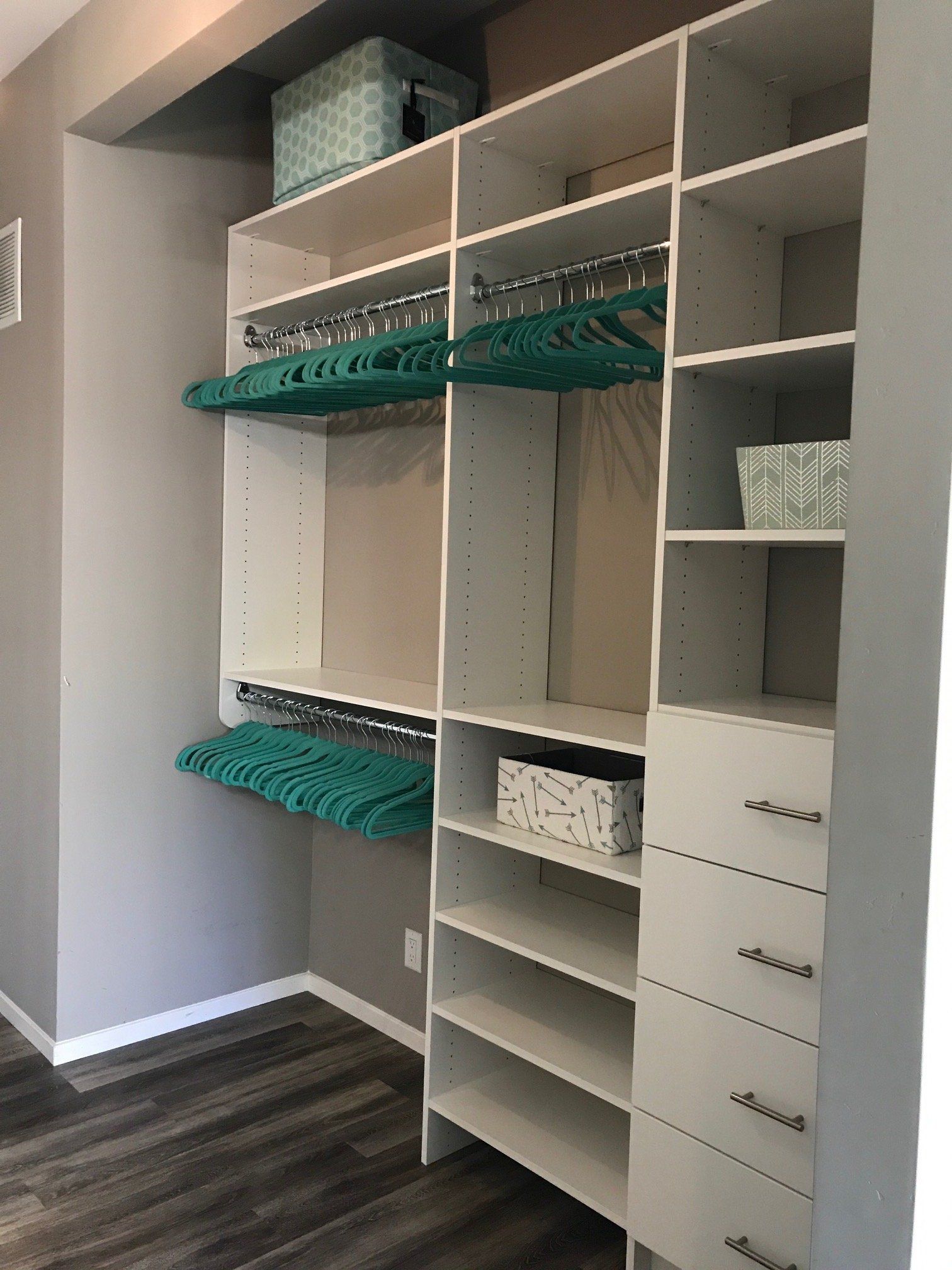 A walk in closet with lots of shelves and drawers.