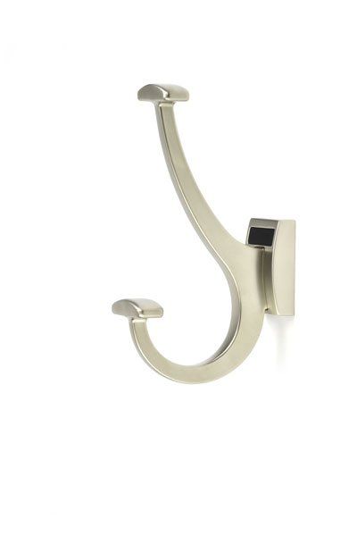 A nickel coat hook is hanging on a white wall.