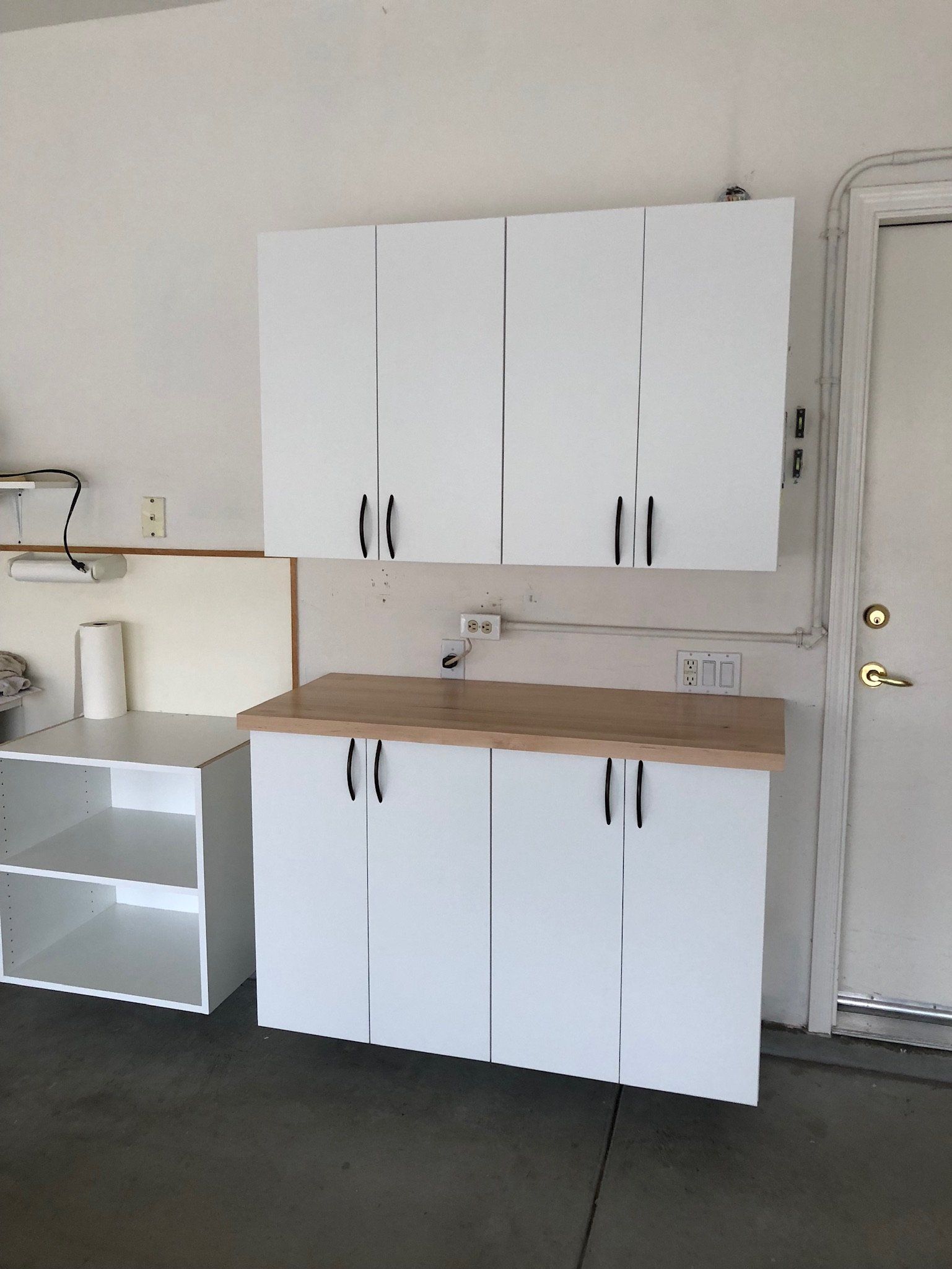 A kitchen with white cabinets and a wooden counter top