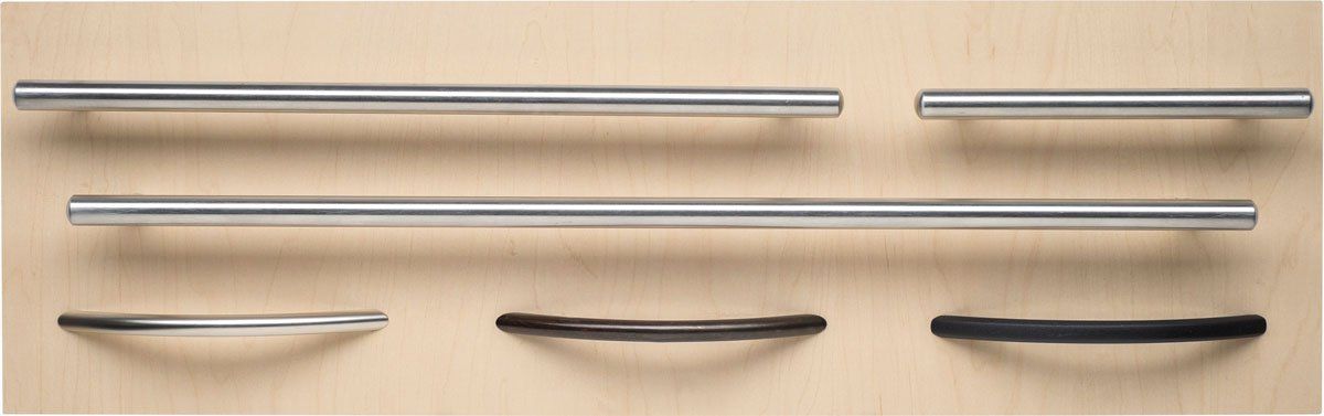 A bunch of metal handles are lined up on a wooden surface.