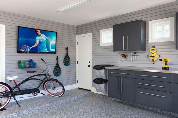 A bicycle is parked in a garage next to a flat screen tv.