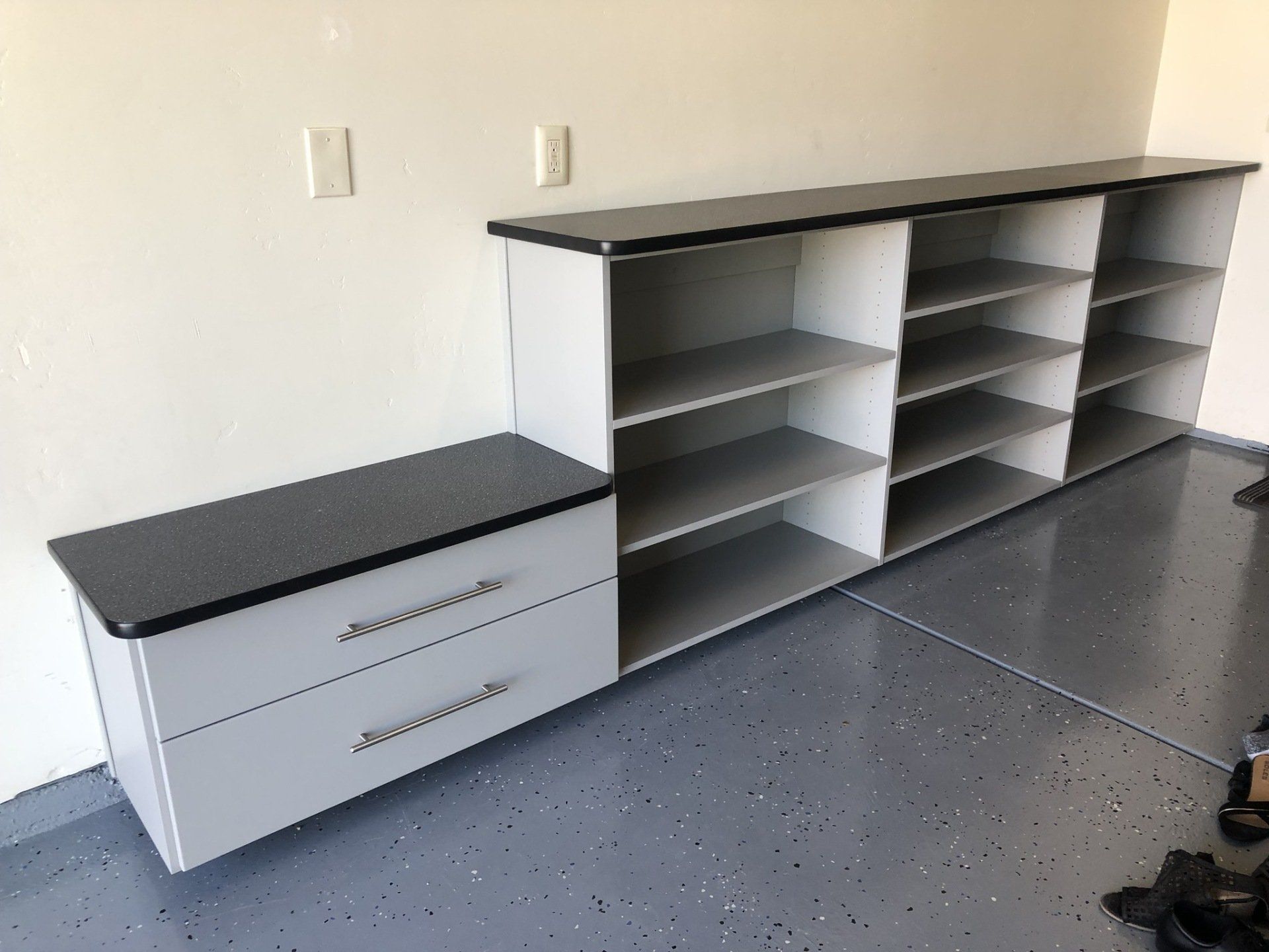 A long shelf with drawers and shelves in a garage