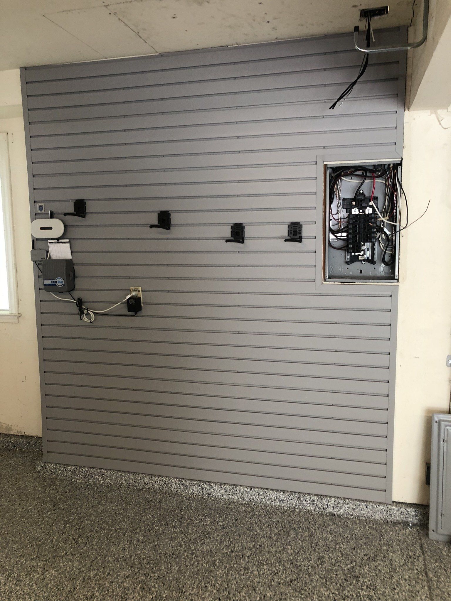 A garage with a gray wall and a gray floor.