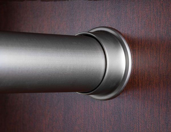 A close up of a metal pipe on a wooden wall.