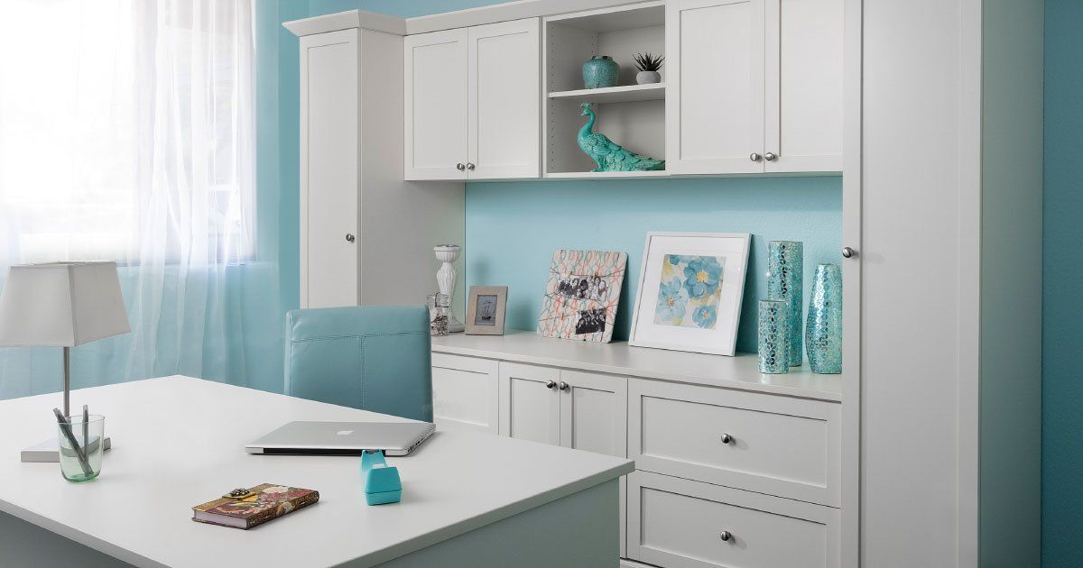 a white desk with a laptop on it in a room with blue walls .