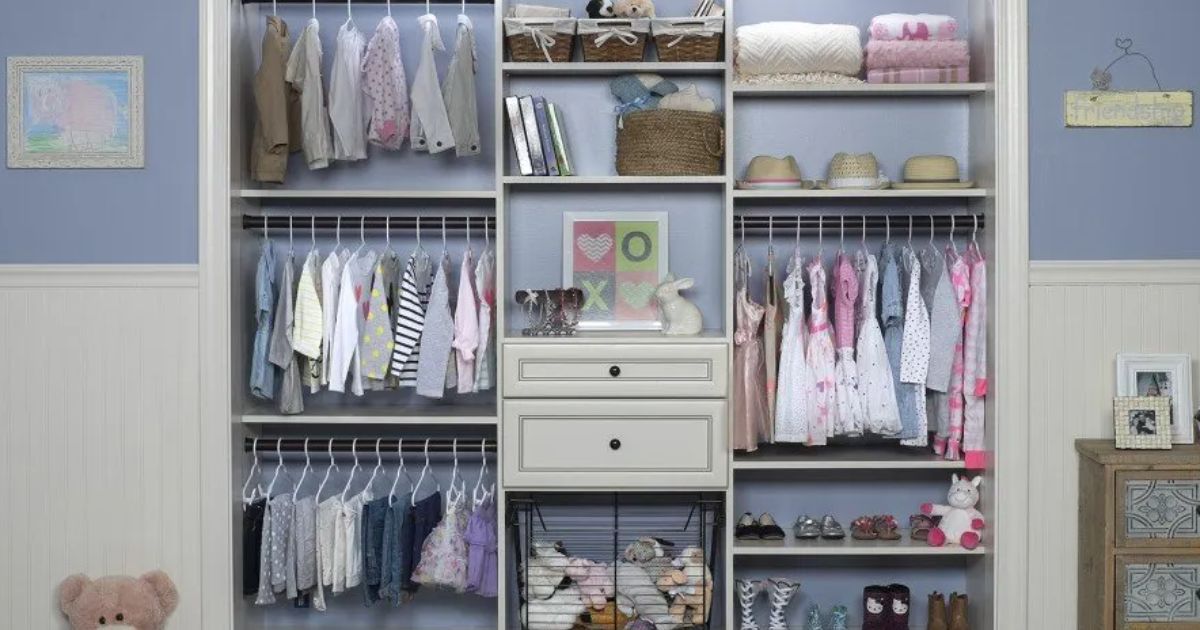 A well-organized nursery closet with white shelving, hanging clothes, drawers, baskets, and shoes on a blue wall.