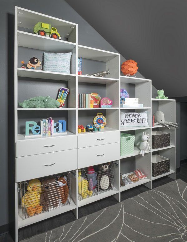 A room with a lot of shelves and drawers filled with toys.