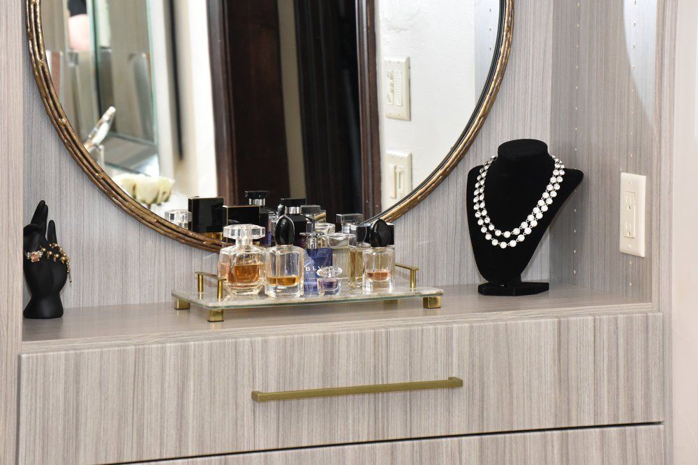 A dresser with a mirror and perfume bottles on it.