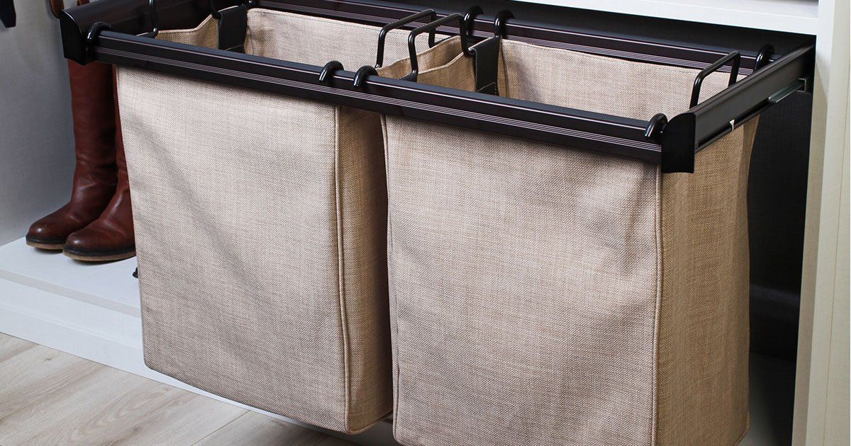 Two laundry baskets are hanging on a rack in a closet.