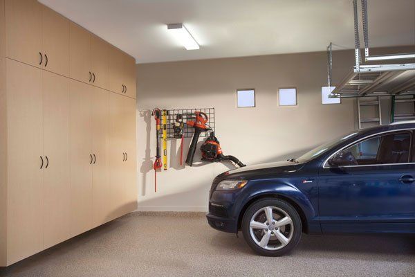 A blue car is parked in a garage.