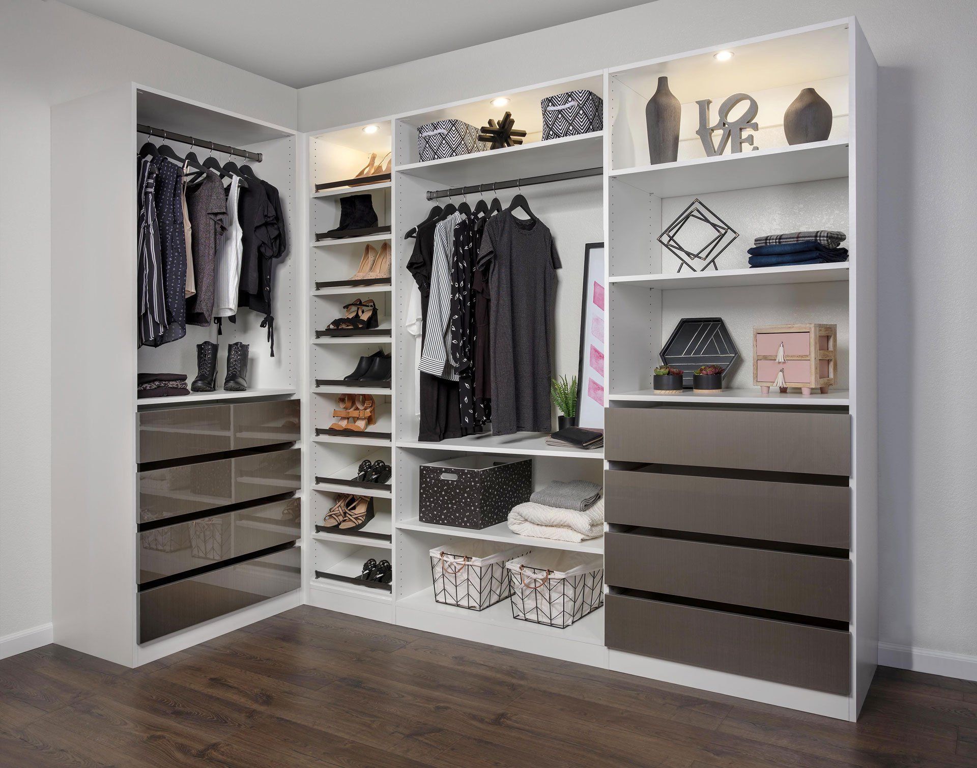 A walk in closet with lots of clothes and drawers.