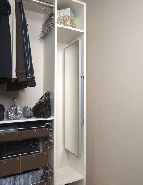 A walk in closet with clothes and a mirror