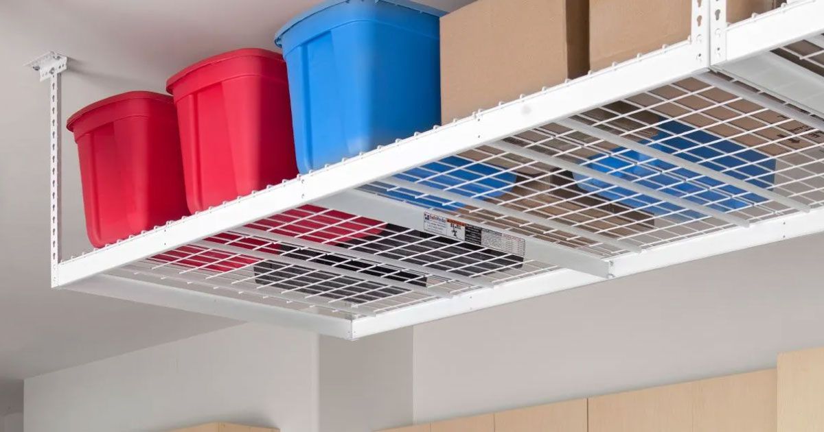 Overhead white storage shelf with red, blue bins and brown boxes.