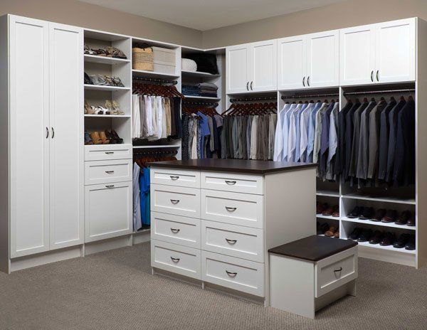 A walk in closet with a large island in the middle