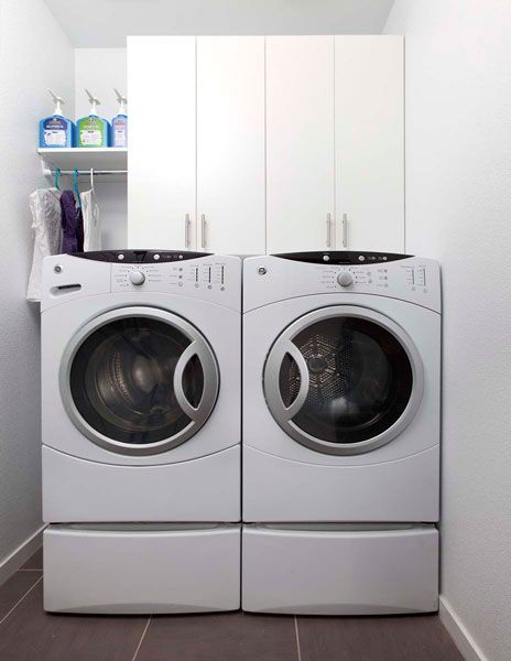 A laundry room with two white washers and dryers.