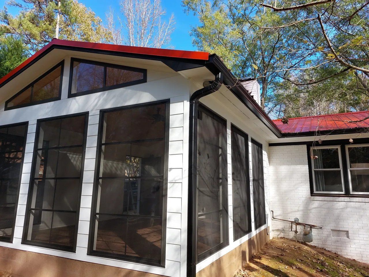 A screened in porch with a red roof